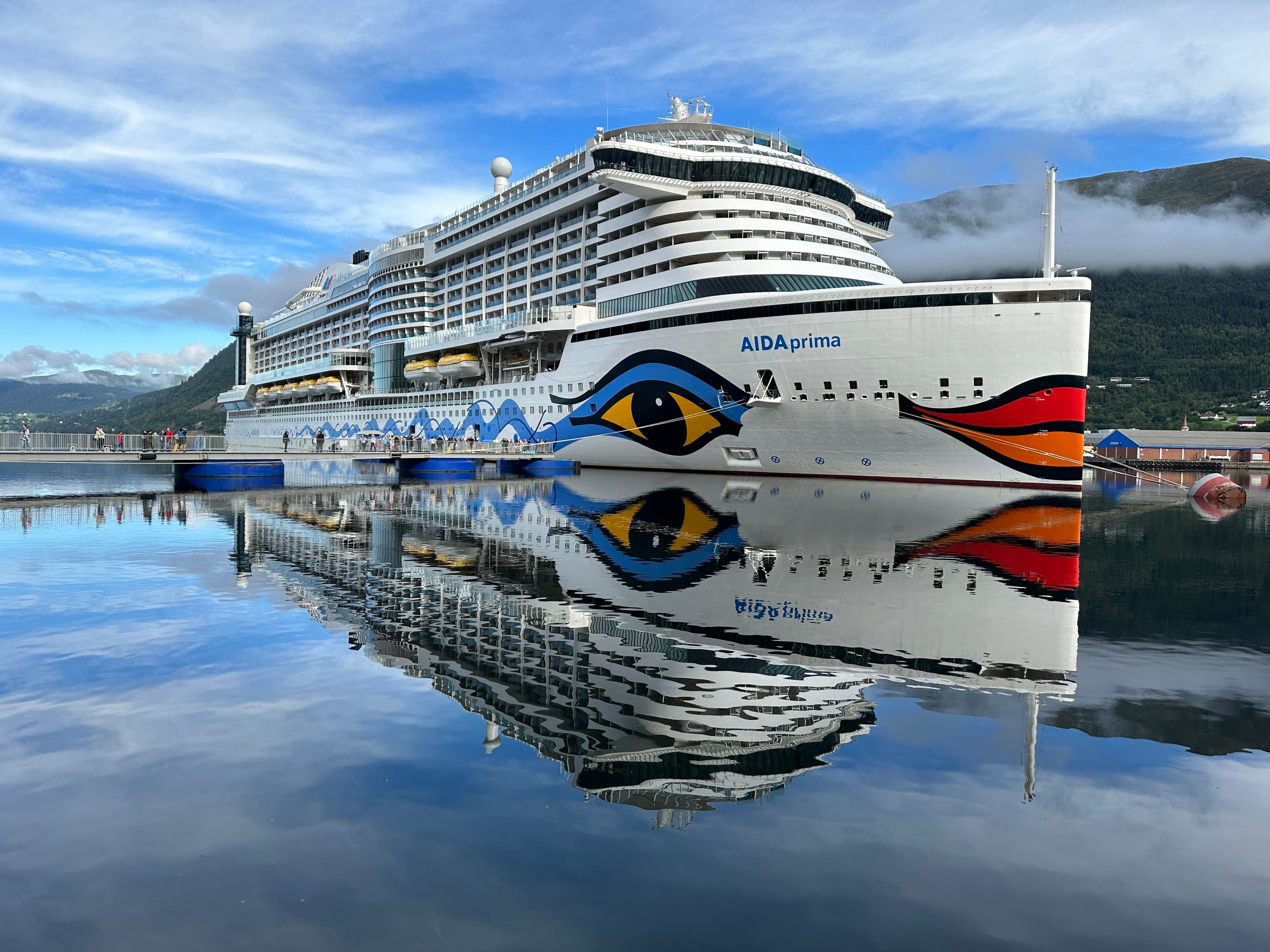 AIDAprima mit perfekter Spiegelung im Fjordhafen