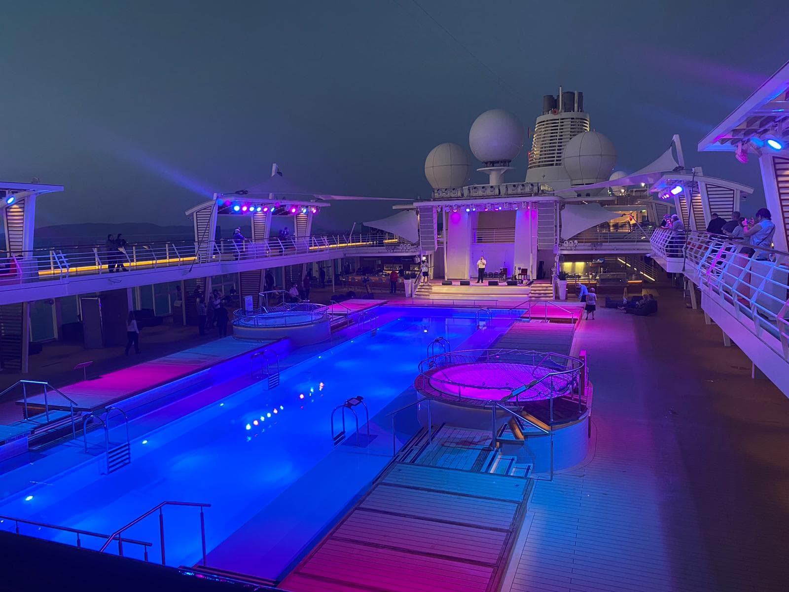 Blaue und lila Lichtshow am Pooldeck eines Kreuzfahrtschiffs bei Nacht