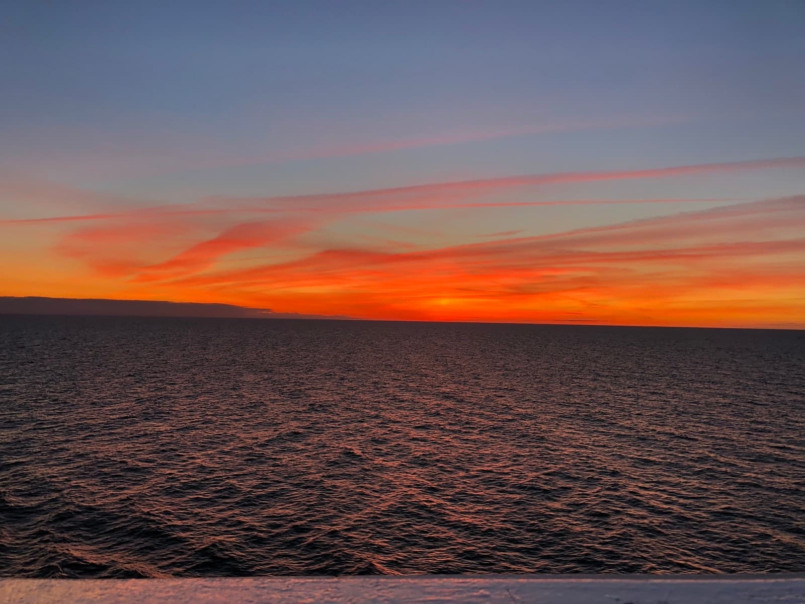 Feuriger orangeroter Sonnenuntergang über dem offenen Meer